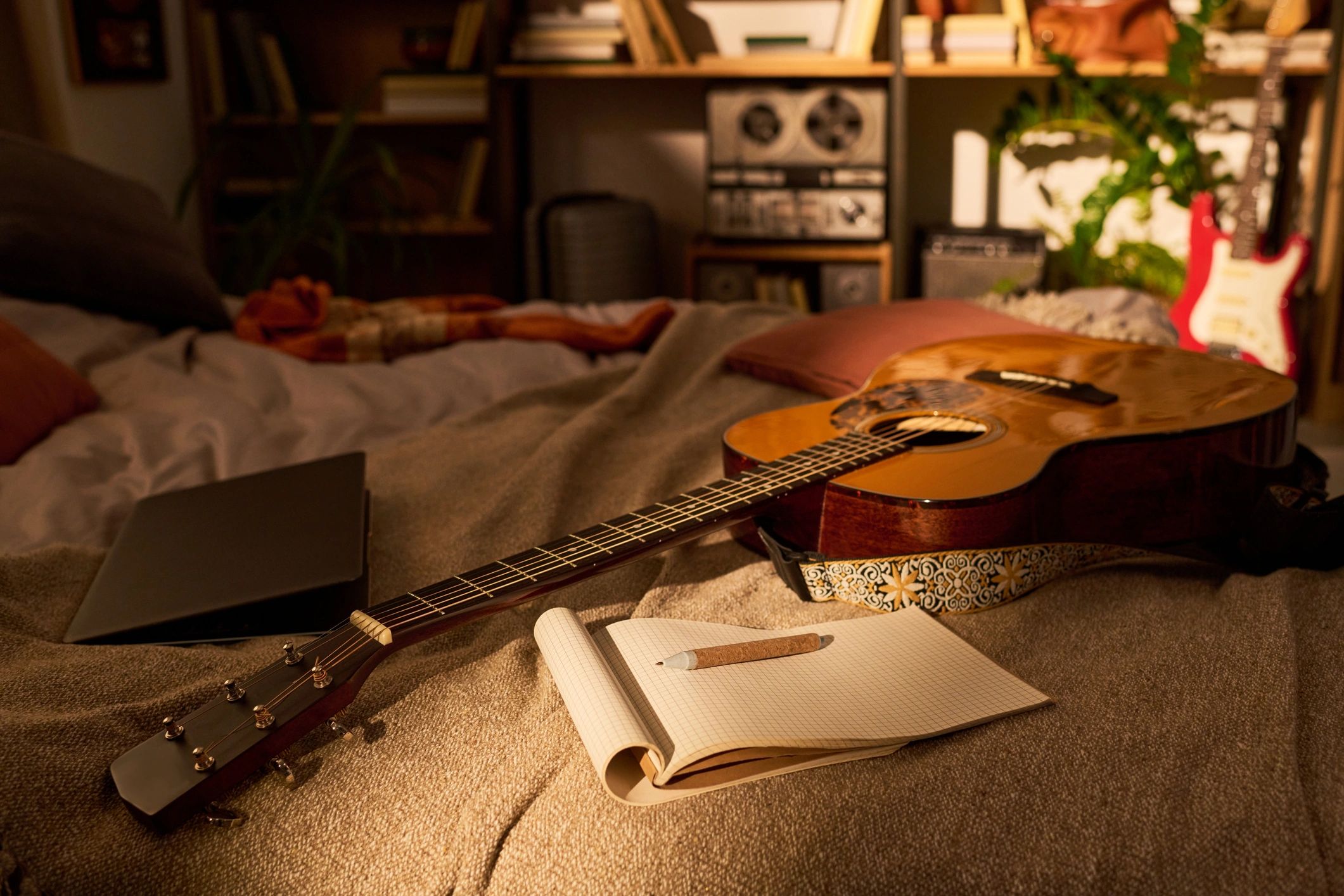 Acoustic guitar and notebook in a songwriting studio setup